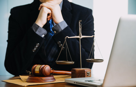 Business and lawyers discussing contract papers with brass scale on desk in office. Law, legal services, advice, justice and law concept picture with film grain effectの写真素材
