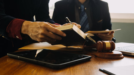 Business and lawyers discussing contract papers with brass scale on desk in office. Law, legal services, advice, justice and law concept picture with film grain effectの写真素材
