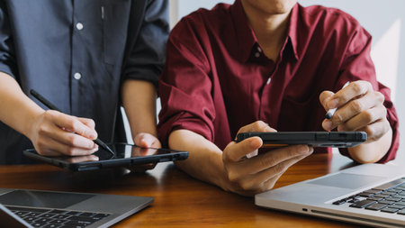 Asian colleagues man and woman discussing and working with laptop computer on office desk in the officeの写真素材