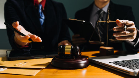 Business and lawyers discussing contract papers with brass scale on desk in office. Law, legal services, advice, justice and law concept picture with film grain effectの写真素材