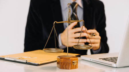Business and lawyers discussing contract papers with brass scale on desk in office. Law, legal services, advice, justice and law conceptの写真素材