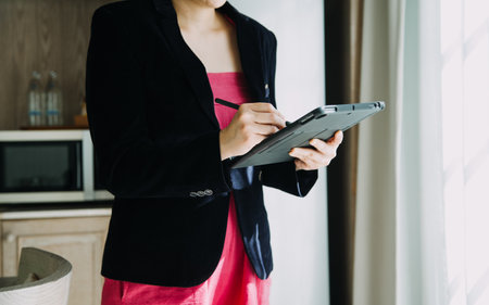 Mature businessman using a digital tablet to discuss information with a younger colleague in a modern business loungeの写真素材