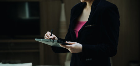Mature businessman using a digital tablet to discuss information with a younger colleague in a modern business loungeの写真素材