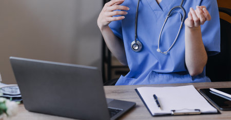 Homecare nursing service and elderly people cardiology healthcare. Close up of young hispanic female doctor nurse check mature caucasian man patient heartbeat using stethoscope during visitの写真素材
