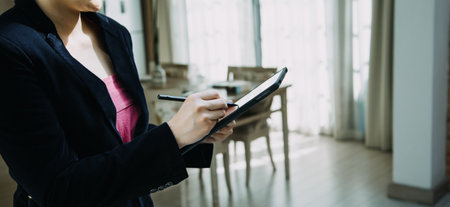 Mature businessman using a digital tablet to discuss information with a younger colleague in a modern business loungeの写真素材