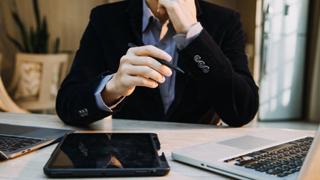 Mature businessman using a digital tablet to discuss information with a younger colleague in a modern business loungeの写真素材