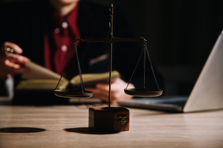 Justice and law concept.Male judge in a courtroom with the gavel, working with, computer and docking keyboard, eyeglasses, on table in morning lightの写真素材