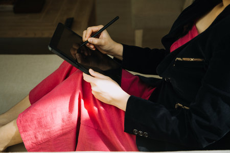 Mature businessman using a digital tablet to discuss information with a younger colleague in a modern business loungeの写真素材