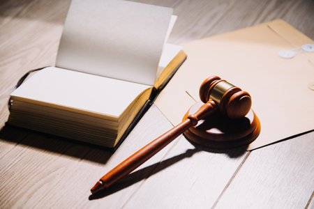 Justice and law concept.Male judge in a courtroom with the gavel, working with, computer and docking keyboard, eyeglasses, on table in morning lightの写真素材