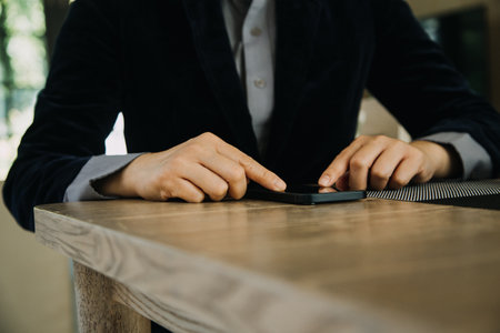 Mature businessman using a digital tablet to discuss information with a younger colleague in a modern business loungeの写真素材