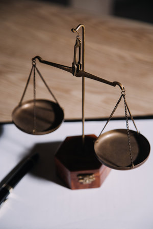 Justice and law concept.Male judge in a courtroom with the gavel, working with, computer and docking keyboard, eyeglasses, on table in morning lightの写真素材