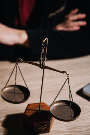 Justice and law concept.Male judge in a courtroom with the gavel, working with, computer and docking keyboard, eyeglasses, on table in morning lightの写真素材