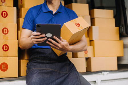 Entrepreneurs Small Business SME Independent men work at home Use smartphones and laptops for commercial checking, online marketing, packing boxes, SME sellers, concept, e-commerce team, online salesの写真素材