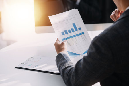 Asian Business woman using calculator and laptop for doing math finance on an office desk, tax, report, accounting, statistics, and analytical research conceptの写真素材