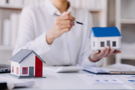 Real estate brokerage agent Deliver a sample of a model house to the customer, mortgage loan agreement Making lease and buy and sell house And contract home insurance mortgage loan conceptの写真素材