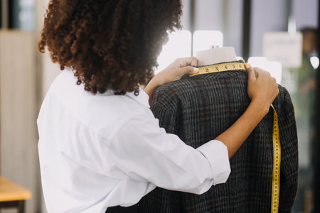 Diverse female fashion designers at work with tailor centimeters on necks and holds tablet and smartphone. independent creative design business. in studioの写真素材