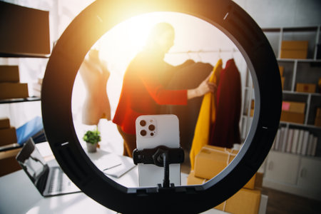 Beautiful lady blogger showing clothes in front of the camera to recording vlog video live streaming...