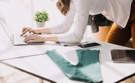 Beautiful lady blogger showing clothes in front of the camera to recording vlog video live streaming at her shop. Online Shopping Cart notion.の写真素材