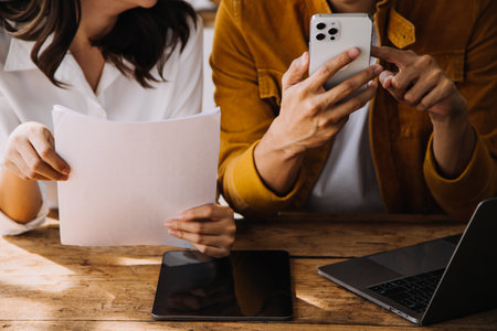 Entrepreneur Asian businessman and businesswoman discussing new business project in tablet in modern Meeting In Modern Office, Asian business casual concept.の写真素材