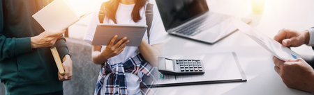 Financial analysts analyze business financial reports on a digital tablet planning investment...