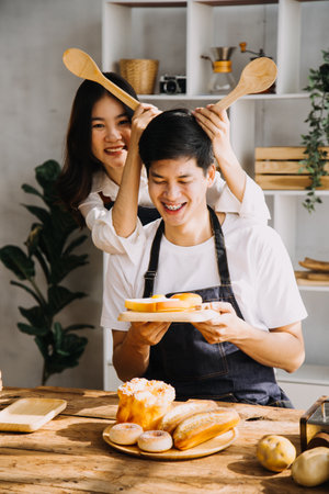 In Kitchen: Perfectly Happy Couple Preparing Healthy Food, Lots of Vegetables. Man Juggles with Fruits, Makes Her Girlfriend Laugh. Lovely People in Love Have Funの写真素材