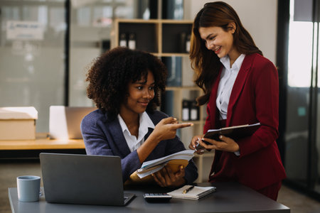 Financial analysts analyze business financial reports on a digital tablet planning investment project during a discussion at a meeting of corporate showing the results of their successful teamwork.の写真素材
