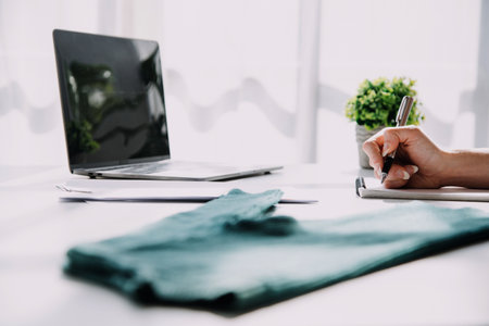 Fashion blogger concept, Young women selling clothes on video streaming.Startup small business SME, using smartphone or tablet taking receive and checking in studioの写真素材