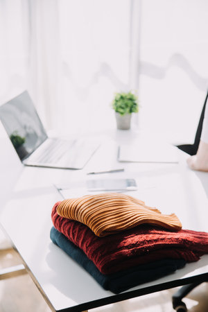 Fashion blogger concept, Young women selling clothes on video streaming.Startup small business SME, using smartphone or tablet taking receive and checking in studioの写真素材