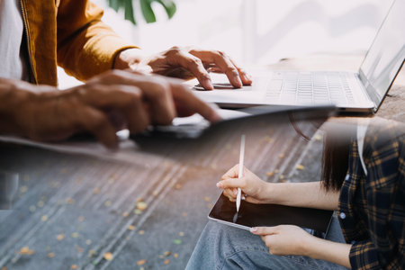 Young adult happy smiling Hispanic Asian student wearing headphones talking on online chat meeting using laptop in university campus or at virtual office. College female student learning remotely.の写真素材