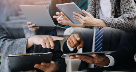 Young adult happy smiling Hispanic Asian student wearing headphones talking on online chat meeting using laptop in university campus or at virtual office. College female student learning remotely.の写真素材