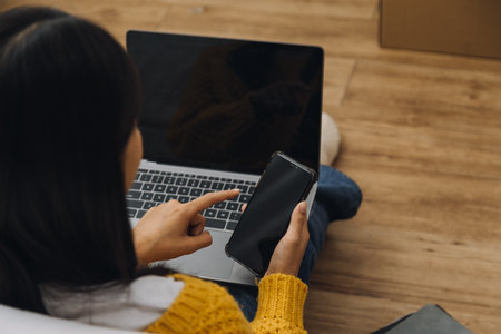 Efficient Young Millennial Girl Sitting on a Bed in the Morning, Uses Laptop Computer and Eats...