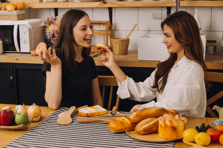 Young woman eating pizza and laughing while sitting with her friends in a restaurant. Group of friends enjoying while having food and drinks at cafe.の写真素材