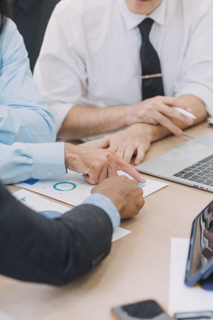 Financial analysts analyze business financial reports on a digital tablet planning investment project during a discussion at a meeting of corporate showing the results of their successful teamwork.の写真素材