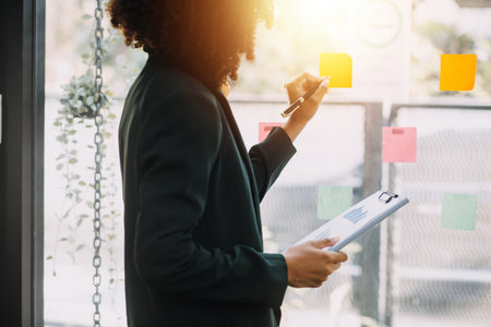 Entrepreneur Asian businessman and businesswoman discussing new business project in tablet in modern Meeting In Modern Office, Asian business casual concept.の写真素材