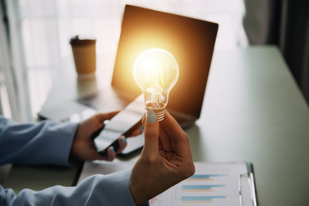 Hand of businessman holding illuminated light bulb with network connection line, idea, innovation and inspiration concept. concept creativity with bulbs that shine glitter.の写真素材