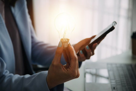 Hand of businessman holding illuminated light bulb with network connection line, idea, innovation and inspiration concept. concept creativity with bulbs that shine glitter.の写真素材
