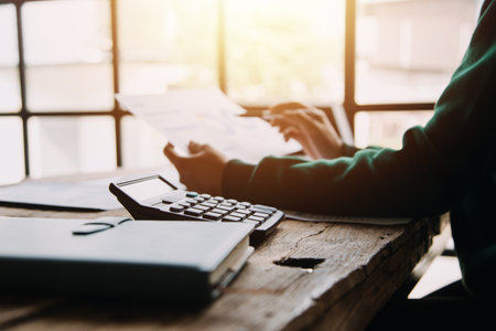 Businesswoman or accountant working Financial investment on calculator, calculate, analyze business and marketing growth on financial document data graph, Accounting, Economic, commercial concept.の写真素材