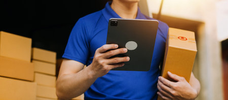 Startup small business entrepreneur of freelance Asian woman using a laptop with box Cheerful success Asian woman her hand lifts up online marketing packaging box and delivery SME idea conceptの写真素材