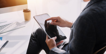 Financial analysts analyze business financial reports on a digital tablet planning investment project during a discussion at a meeting of corporate showing the results of their successful teamwork.の写真素材