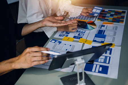Close up ux developer and ui designer brainstorming about mobile app interface wireframe design on...