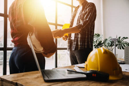 Two business man construction site engineer. Engineering objects on workplace with partners interacting on backgroundの写真素材