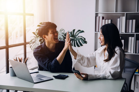 Group of Young Asian business team creative businesspeople coworker in office Happy to be successful partnership teamwork celebrating achievement and success concept.の写真素材