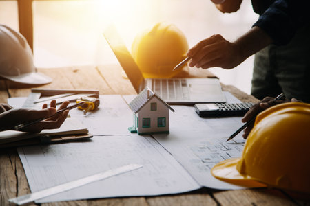 Construction and structure concept of engineer working drawing on blueprint meeting for project working with partner on model building and engineering tools in working site, construction conceptの写真素材