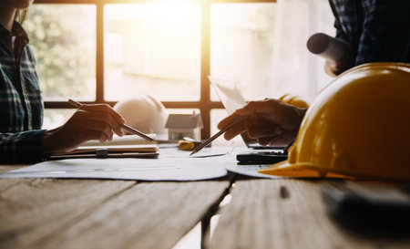 Construction and structure concept of engineer working drawing on blueprint meeting for project working with partner on model building and engineering tools in working site, construction conceptの写真素材