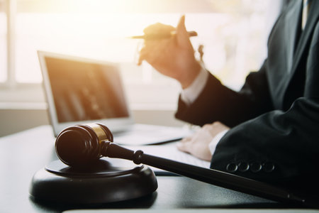 Justice and Law concept. Legal counsel presents to the client a signed contract with gavel and legal law or legal having team meeting at law firm in backgroundの写真素材