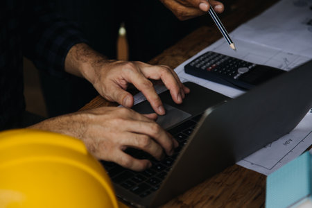 Construction and structure concept of engineer working drawing on blueprint meeting for project working with partner on model building and engineering tools in working site, construction conceptの写真素材