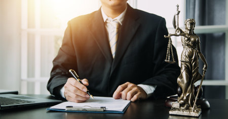 Justice and Law concept. Legal counsel presents to the client a signed contract with gavel and legal law or legal having team meeting at law firm in backgroundの写真素材