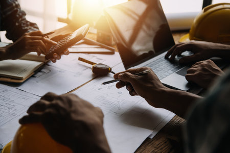 Construction and structure concept of engineer working drawing on blueprint meeting for project working with partner on model building and engineering tools in working site, construction conceptの写真素材