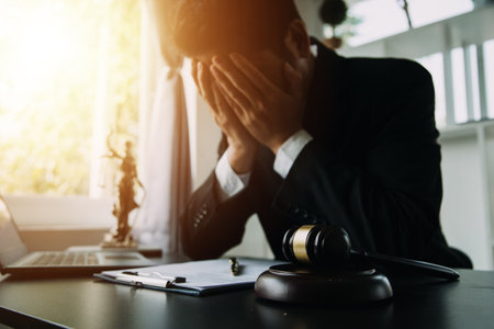 Justice and Law concept. Legal counsel presents to the client a signed contract with gavel and legal law or legal having team meeting at law firm in backgroundの写真素材