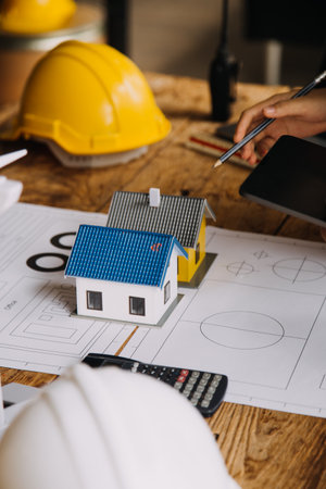 Construction and structure concept of engineer working drawing on blueprint meeting for project working with partner on model building and engineering tools in working site, construction conceptの写真素材